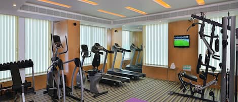 A gym with treadmills, elliptical machines, and weight equipment.