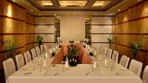 A conference room with a long table, white chairs, and a central floral arrangement. - Peerless Hotel Kolkata (Kolkata)