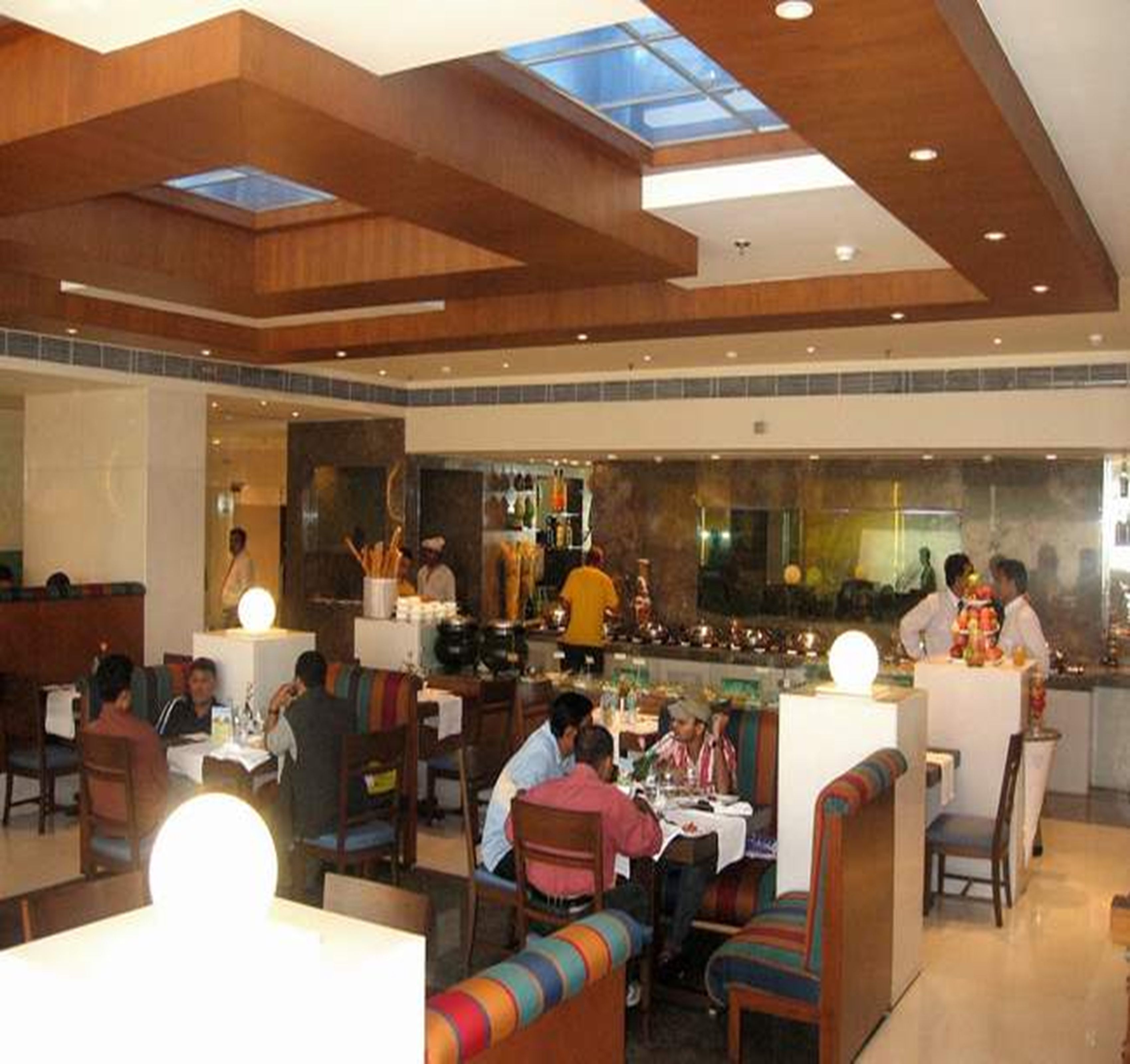 A restaurant with high ceilings, skylights, and a bar area.