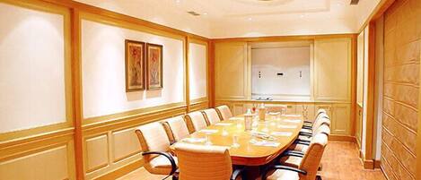 A conference room with a long table, chairs, and a whiteboard.