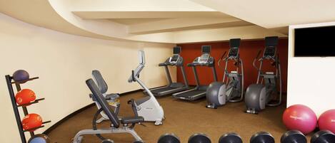 A gym with treadmills, elliptical machines, and free weights.