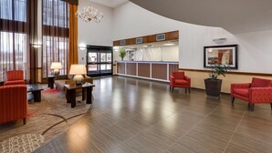 Um hall amplo com balcão de recepção, área de estar e um candelabro.