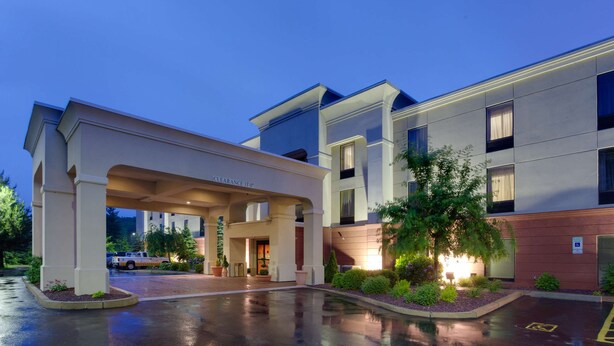 A hotel entrance with a covered walkway, a parking area, and a well-lit building facade. - Hampton Inn Auburn (Auburn)