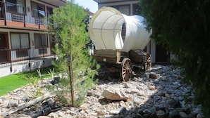 A covered wagon in a courtyard with a building in the background.