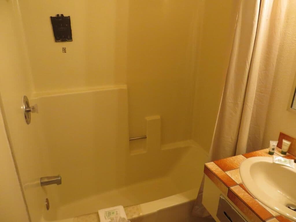 A bathroom with a bathtub, a sink, and a shower curtain.