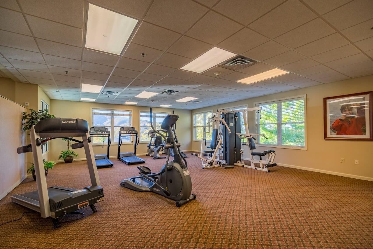 A gym with treadmills, an elliptical, and weight machines.