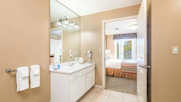 A hotel bathroom with a large mirror, two sinks, and a towel rack.