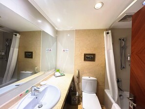 A modern bathroom with a large mirror, a sink, a toilet, and a shower area.