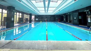 An indoor swimming pool with clear lanes, a skylight ceiling, and a lifeguard station. - Holiday Inn Beijing Temple Of Heaven by IHG (Beijing)