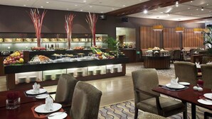 A hotel dining area with a buffet setup, multiple seating arrangements, and a modern interior design. - Holiday Inn Beijing Temple Of Heaven by IHG (Beijing)