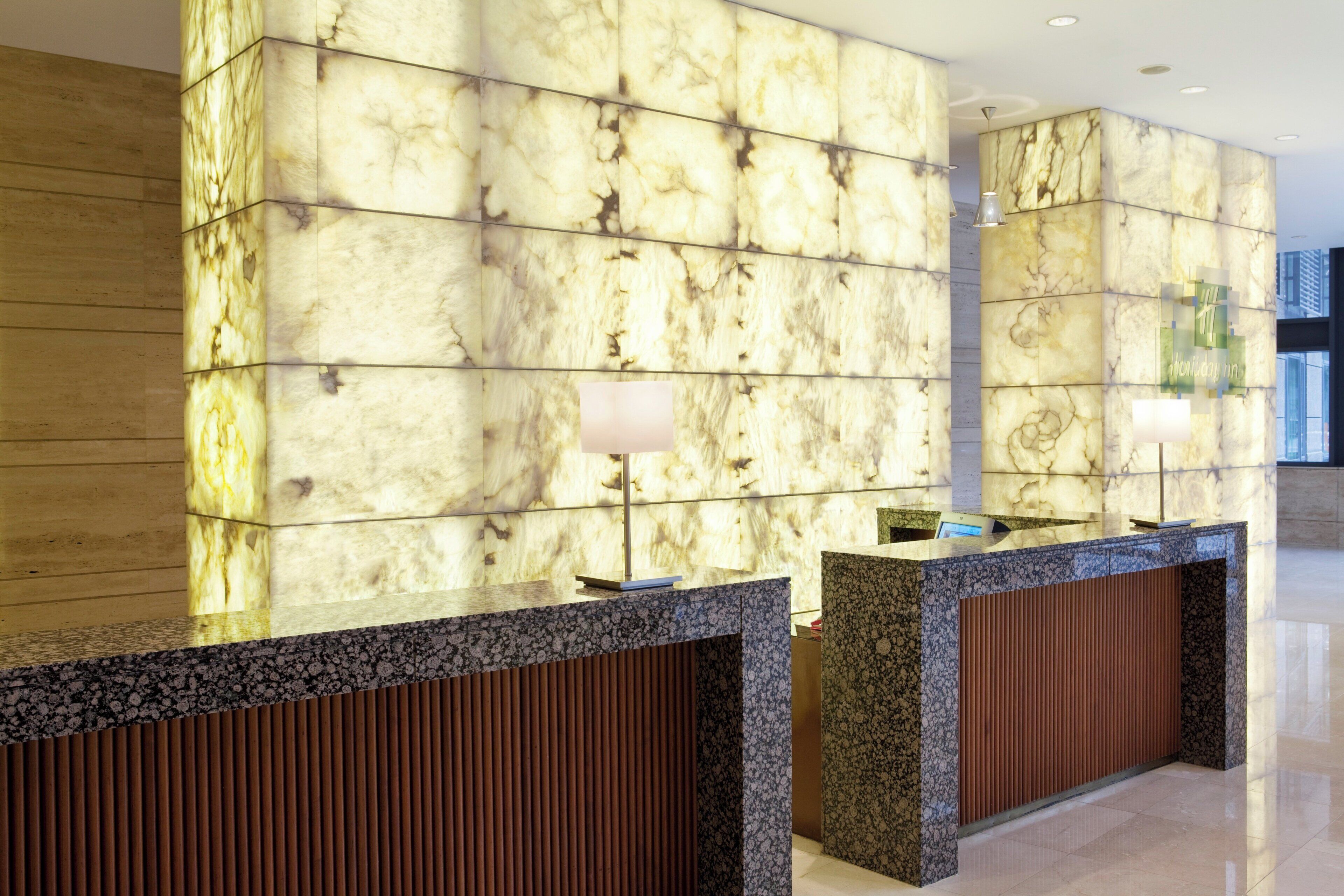 A reception area with marble walls and a reception desk.