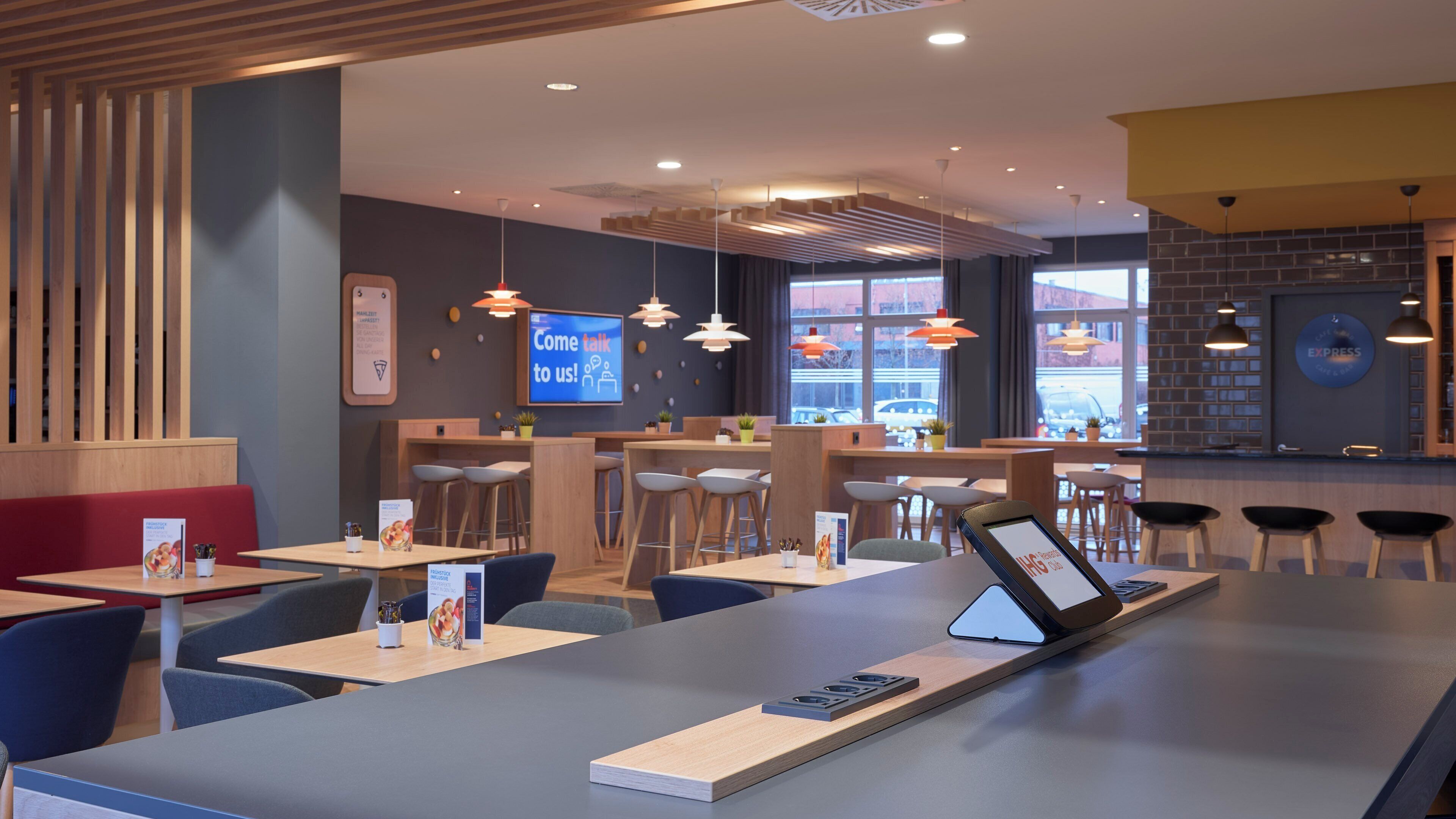 Un interior de restaurante moderno con cabinas, mesas y una zona de bar.