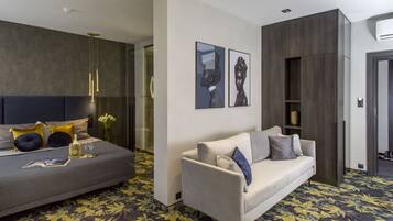 Een moderne hotelkamer met een bed, een bank en een grote spiegel.