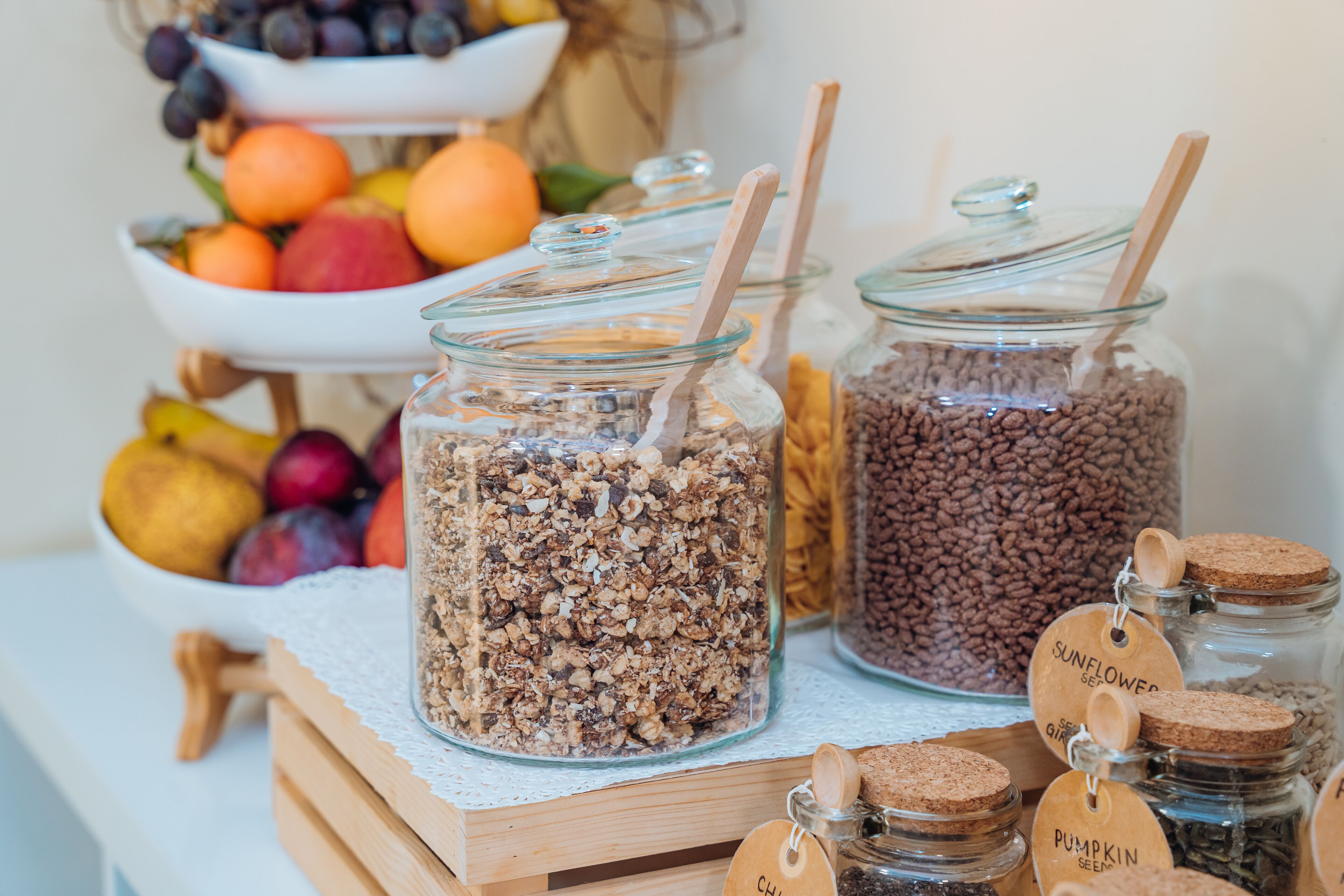 A food display with various jars labeled with ingredients like sunflower seeds, pumpkin seeds, and chickpeas.