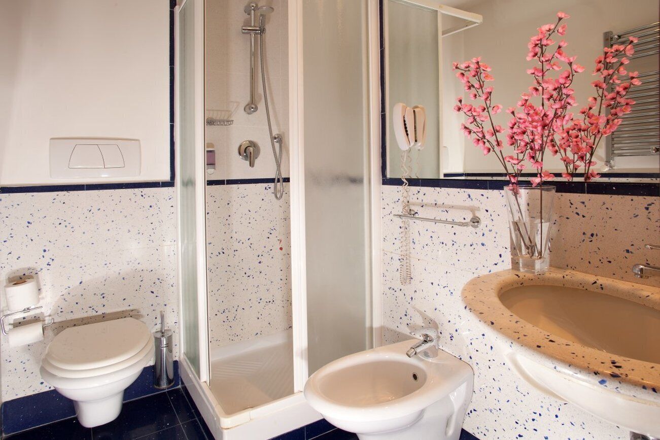 Een badkamer met toilet, bidet en wastafel.