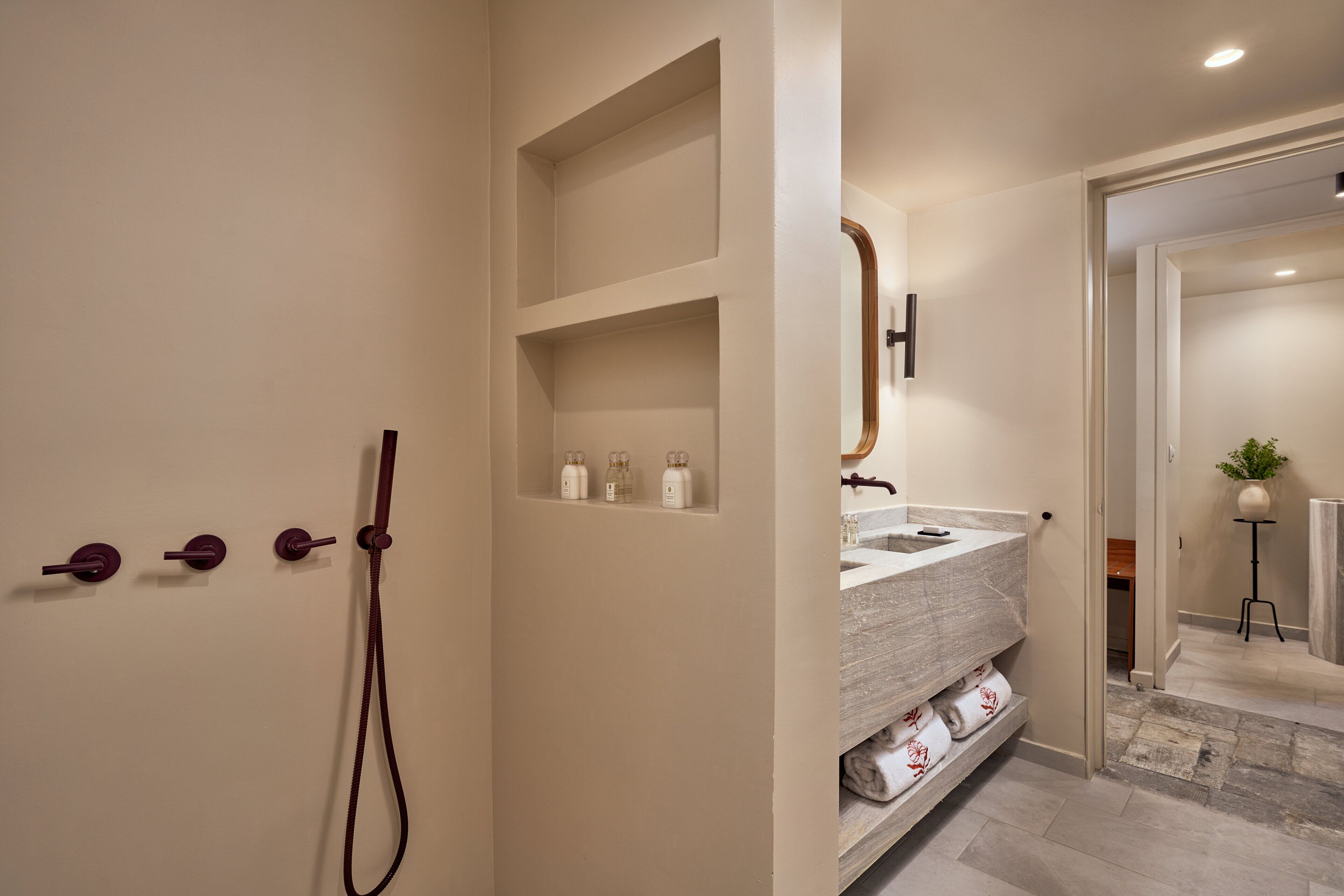 Ein modernes Badezimmer mit integriertem Waschbecken, einem Spiegel und einer Duschkabine.
