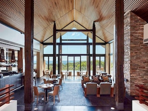 Un espacio interior amplio con techo alto, ventanas grandes y vistas al exterior.