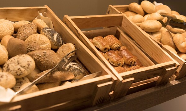 Three wooden bread baskets filled with various types of bread. - Ramada by Wyndham Hannover (Laatzen)