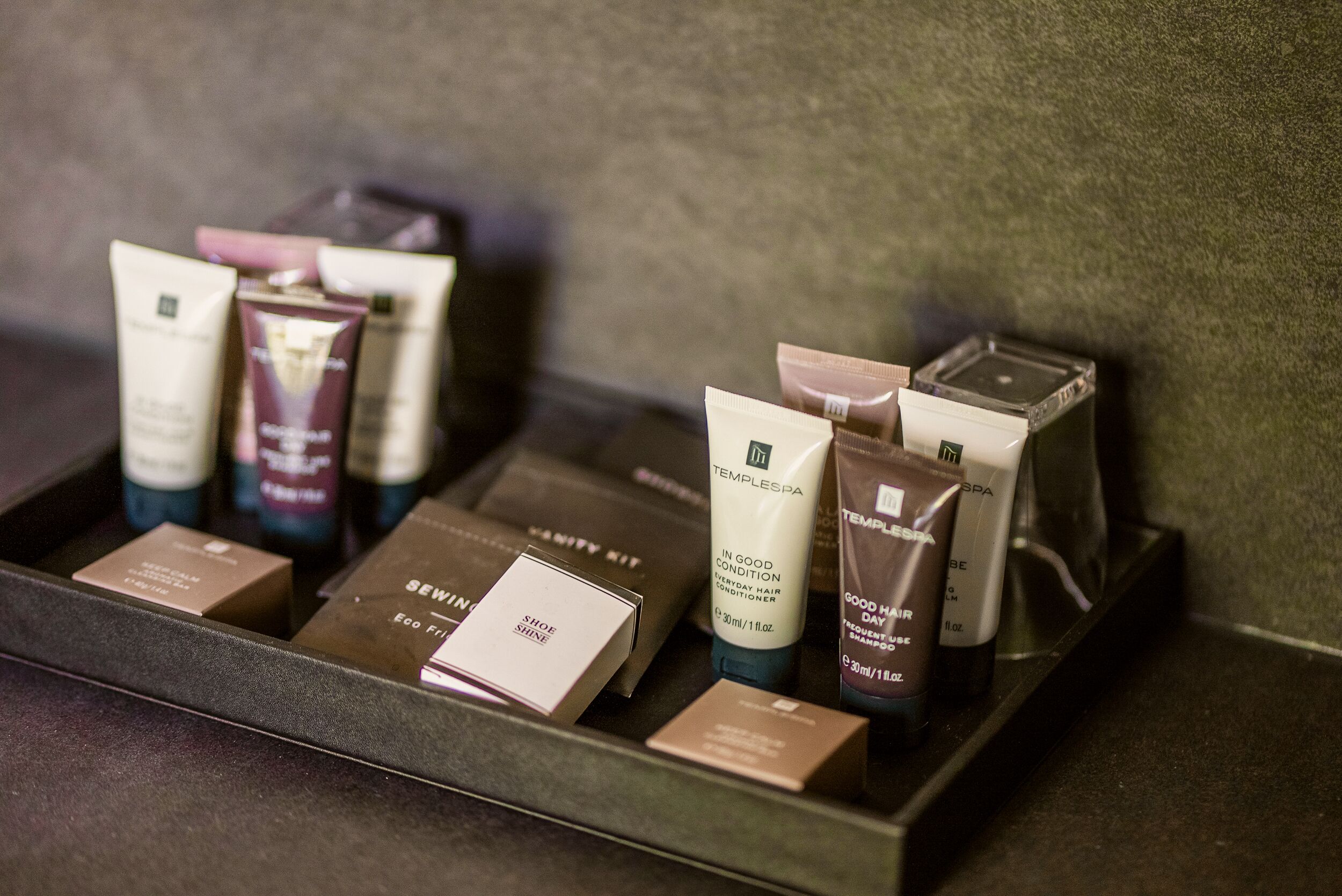 A tray with various toiletries including a tube labeled "TEMPLESPA" and several boxes.