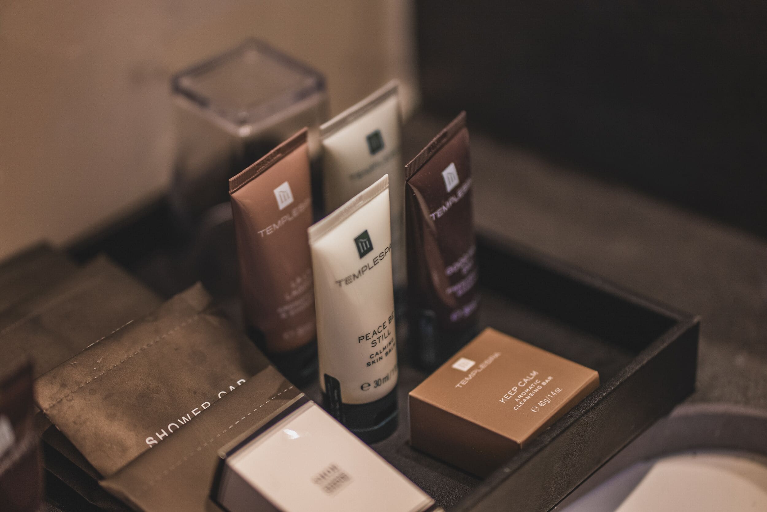 A tray with various skincare products, including tubes and boxes, likely in a hotel setting.