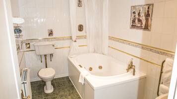 A bathroom with a bathtub, toilet, and sink.