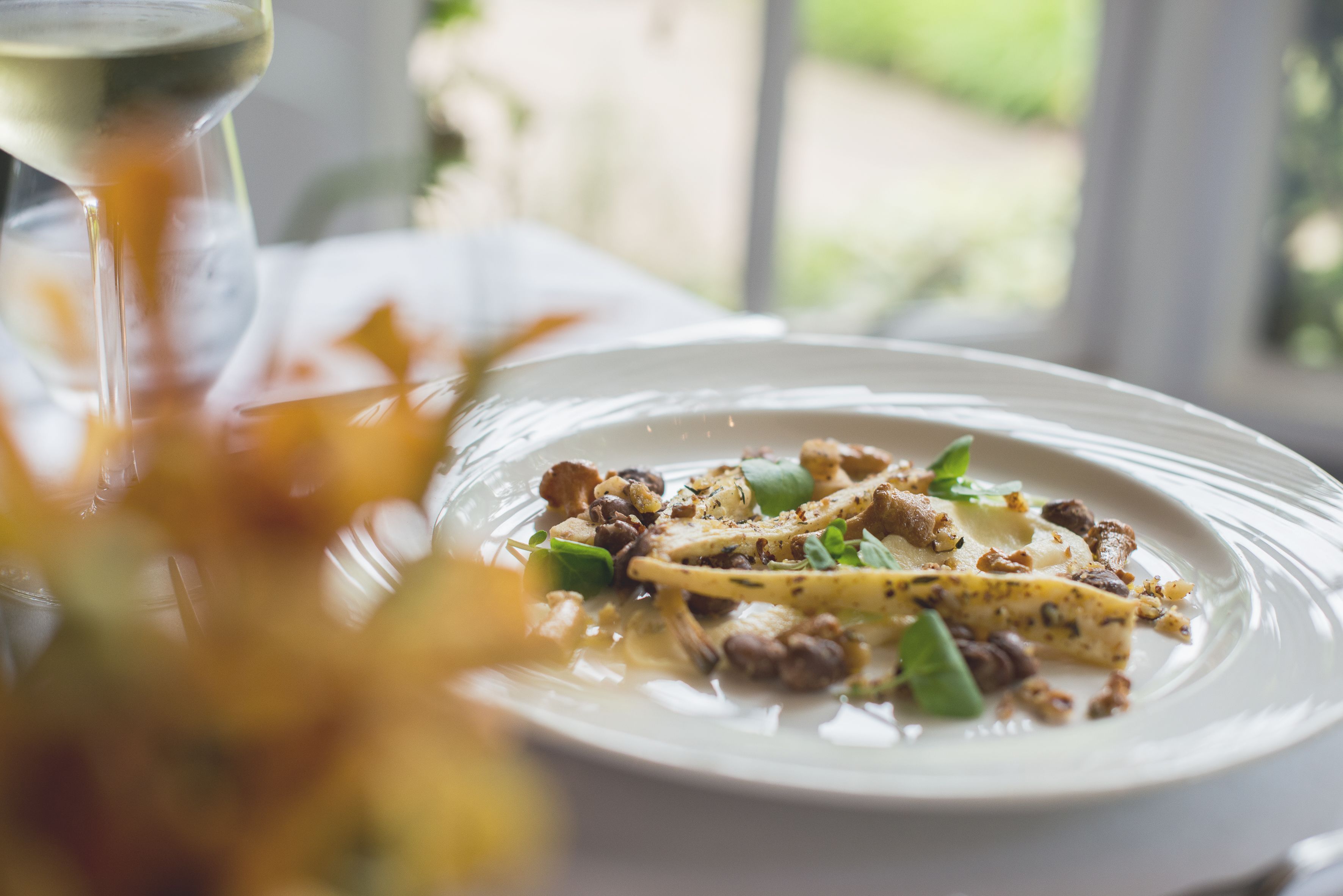 A plate of food with a glass of wine on a table.
