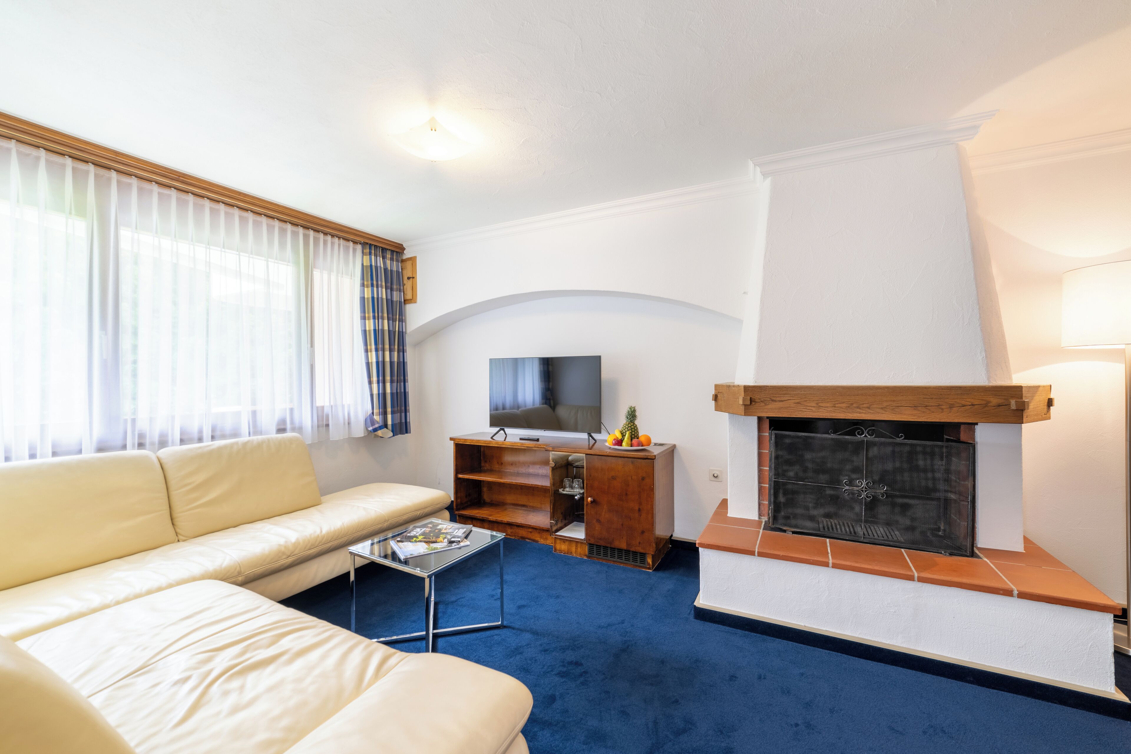 Una sala de estar con un sofá, una mesa de centro, un televisor y una chimenea.