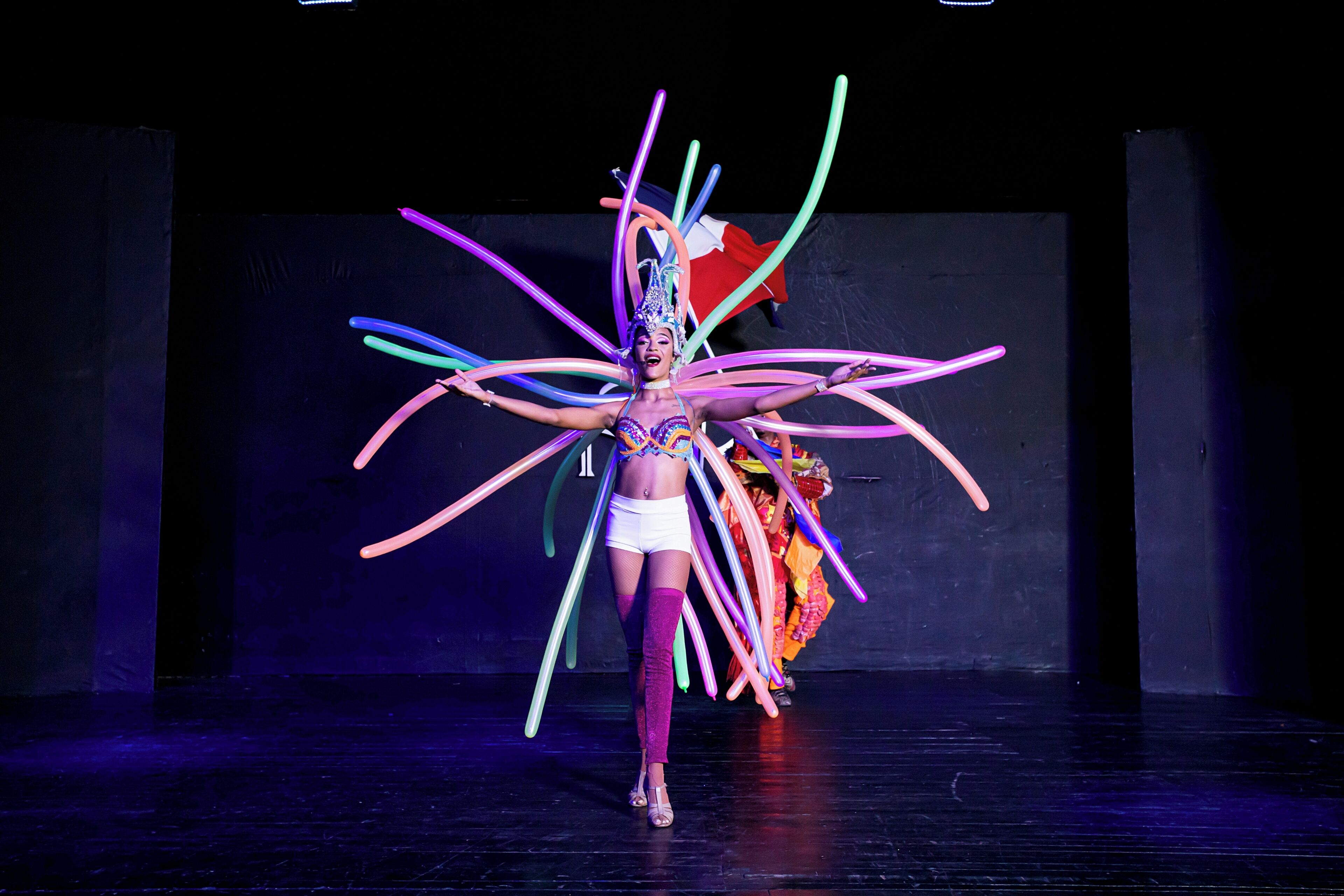 A performer on stage with colorful props.