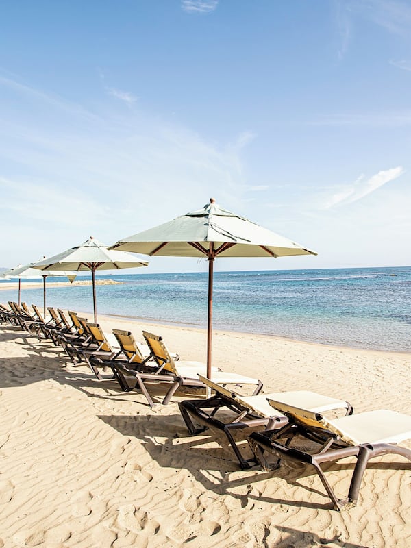 On the beach, white sand, sun loungers, beach umbrellas