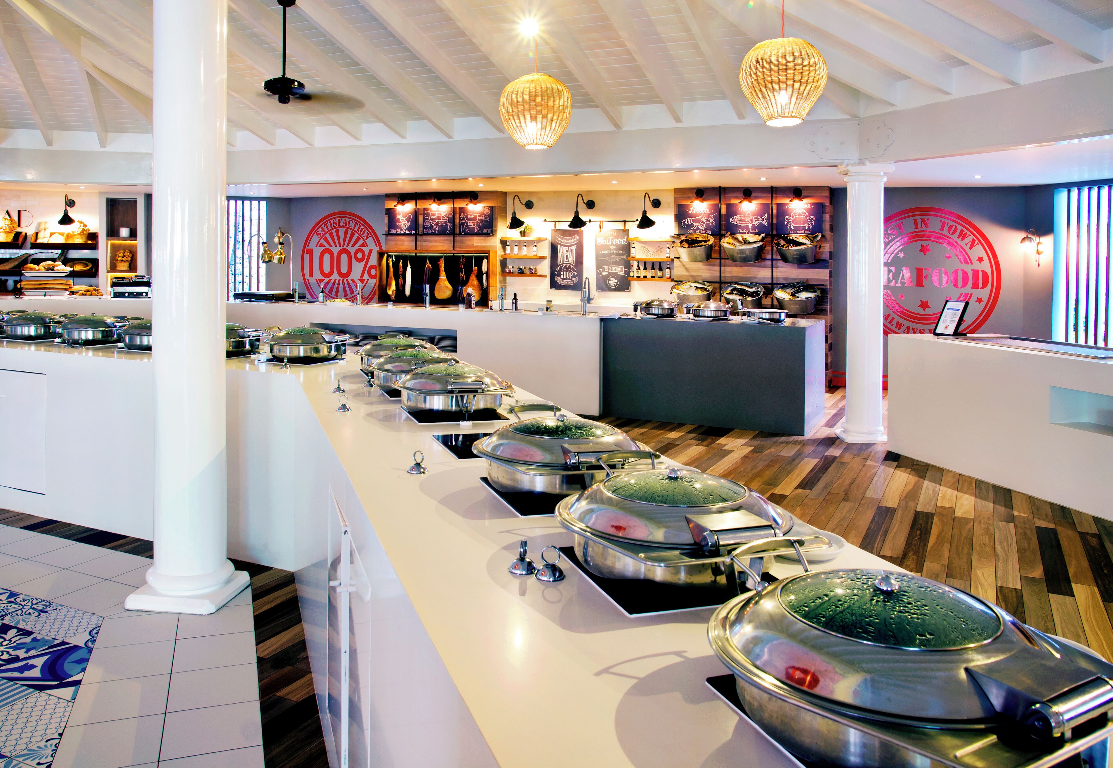 Un buffet avec plusieurs stands de nourriture, un espace d’accueil et un panneau indiquant « 100 % produits de la mer ».