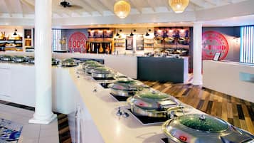 Un buffet avec plusieurs stands de nourriture, un espace d’accueil et un panneau indiquant « 100 % produits de la mer ».