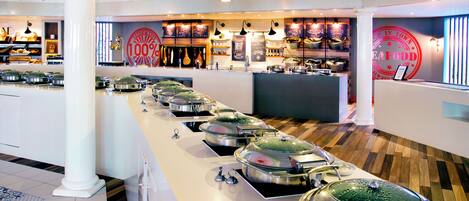 A buffet setup with multiple food stations, a reception area, and a '100% Seafood' sign.