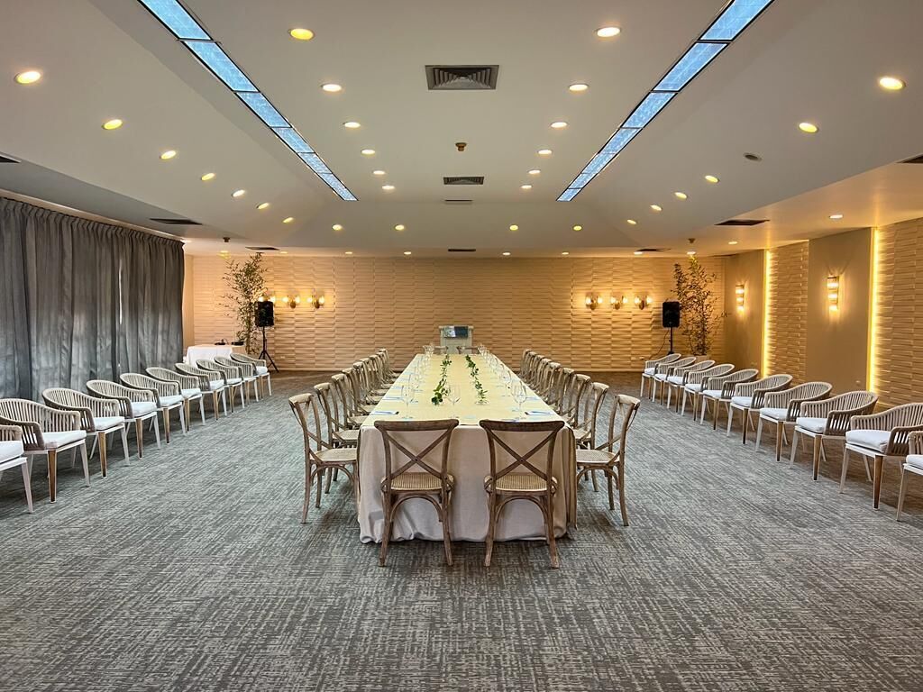 A conference room with a long table, chairs, and a carpeted floor.