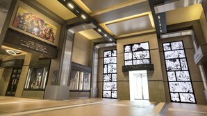 Un vestíbulo amplio con techos altos, iluminación moderna y un mural grande.