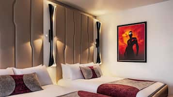 A modern hotel room with a large bed, a headboard with vertical lines, and a framed artwork on the wall.