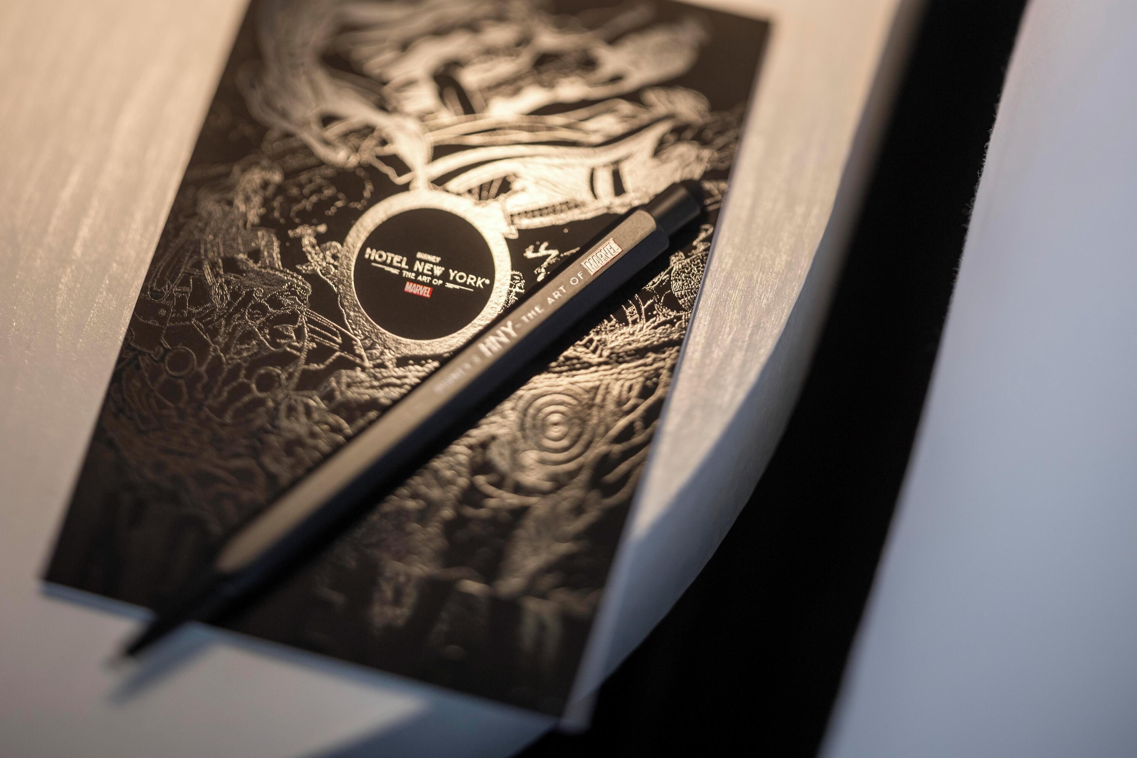 A black and white brochure with intricate designs and the text "HOTEL NEW YORK THE ART OF NATURE".