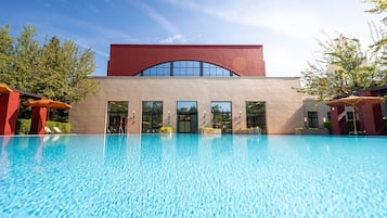 Una piscina cubierta, una piscina al aire libre de temporada, sombrillas
