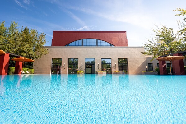 A modern building with a large swimming pool in front. - Disney Hotel New York - The Art of Marvel (Chessy)