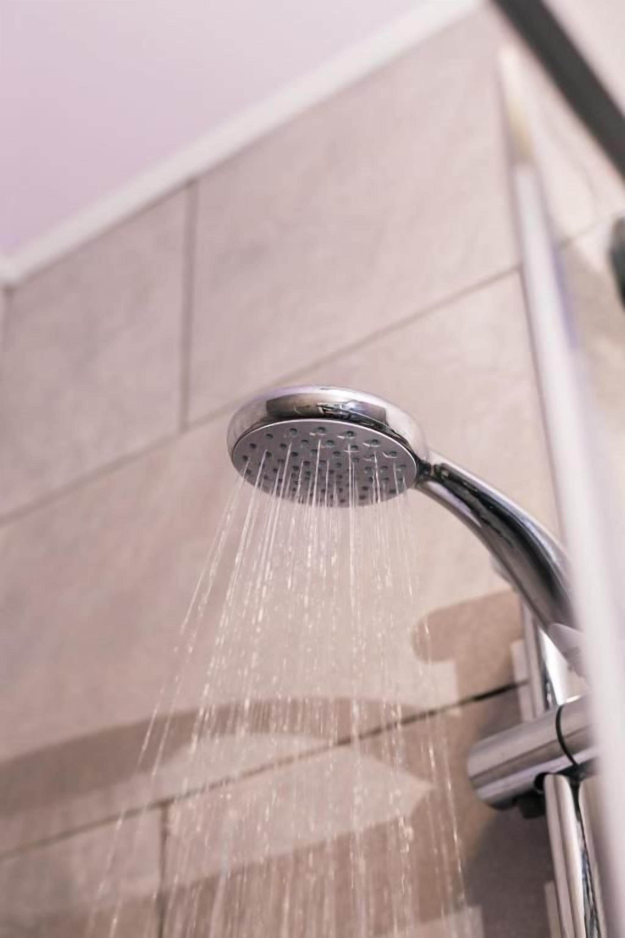 A showerhead with water flowing from it.