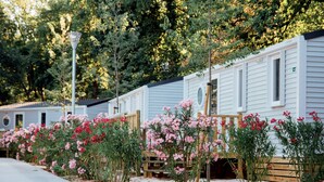 Une rangée de maisons mobiles avec un petit jardin devant.