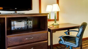 A hotel room with a flat-screen TV, a microwave, a desk with a lamp, and a blue chair. - Econo Lodge Sharon - Foxborough (Sharon)