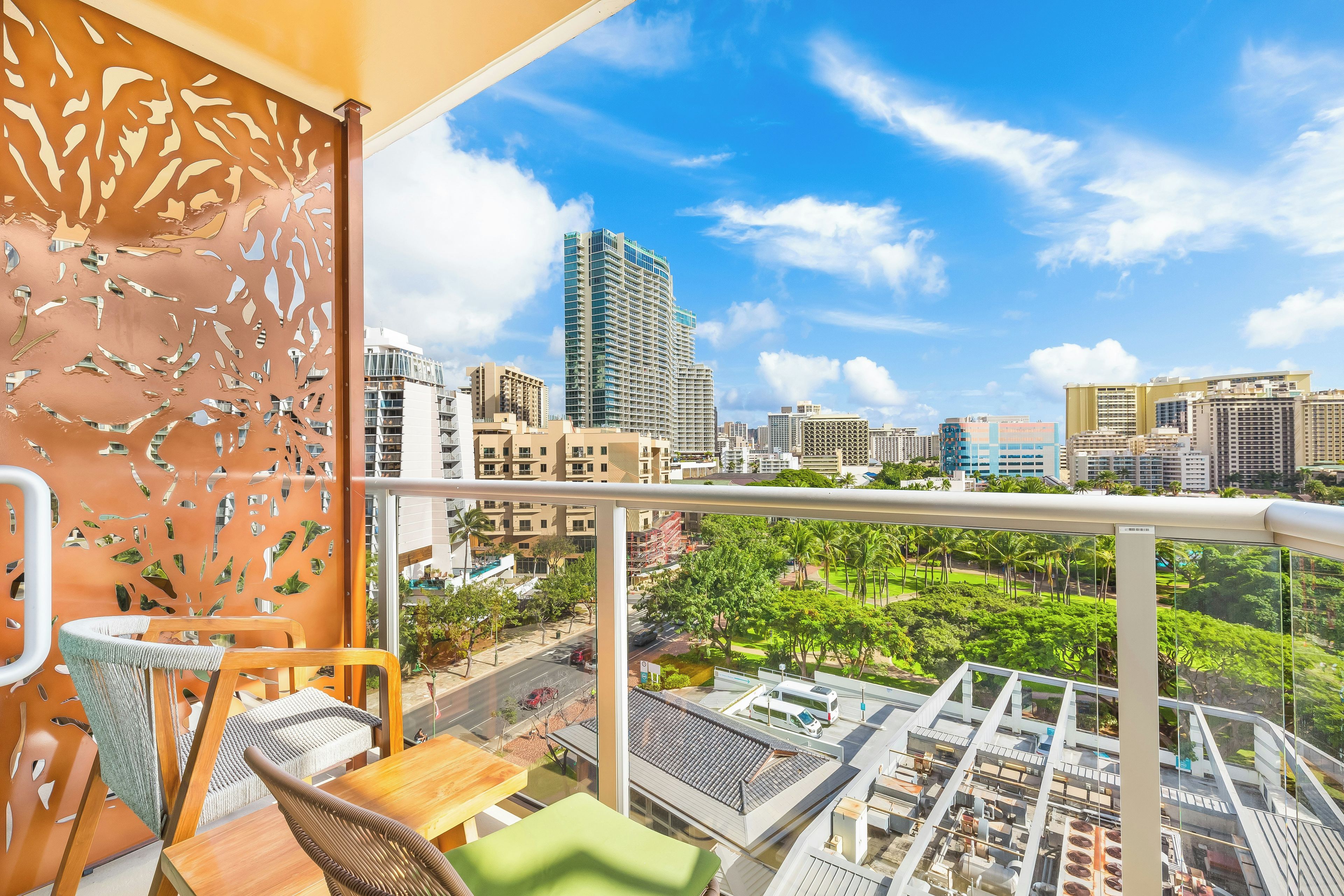 Ein Balkon mit Blick auf die Stadt, ein Tisch, Stühle und eine Zierwand.