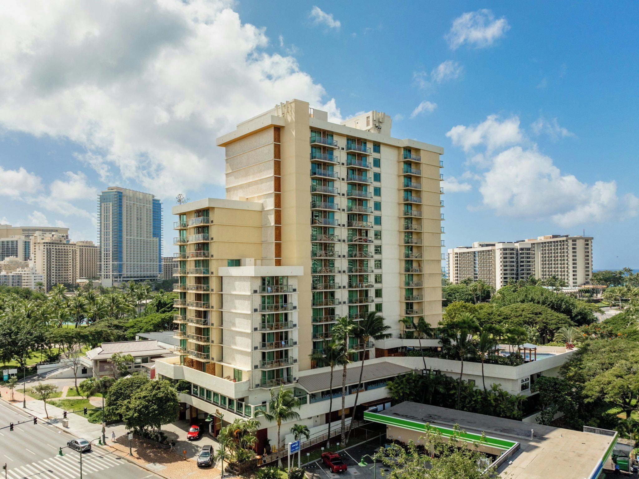 Un hôtel à plusieurs étages au design moderne, doté de balcons et d’un espace piscine sur le toit.