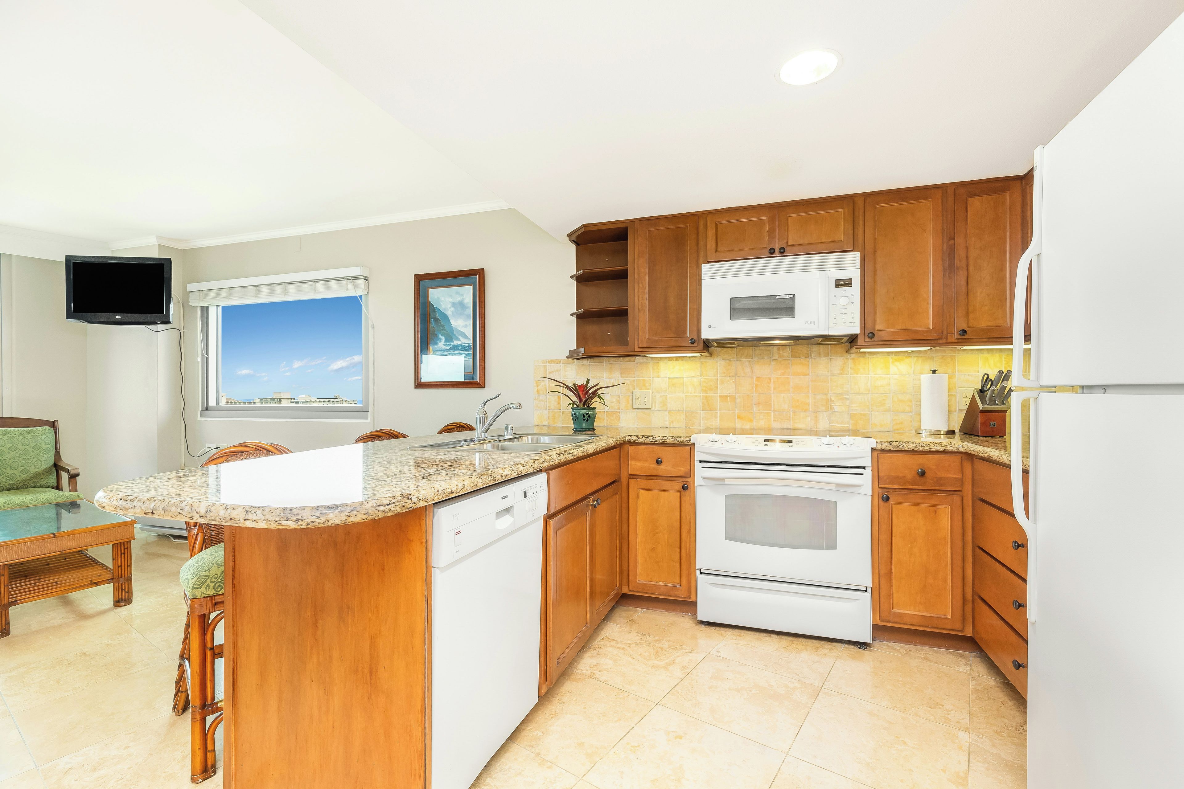 A kitchen with wooden cabinets, a built-in microwave, an oven, and a dishwasher.