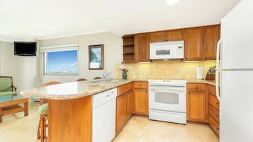 A kitchen with wooden cabinets, a built-in microwave, an oven, and a dishwasher.