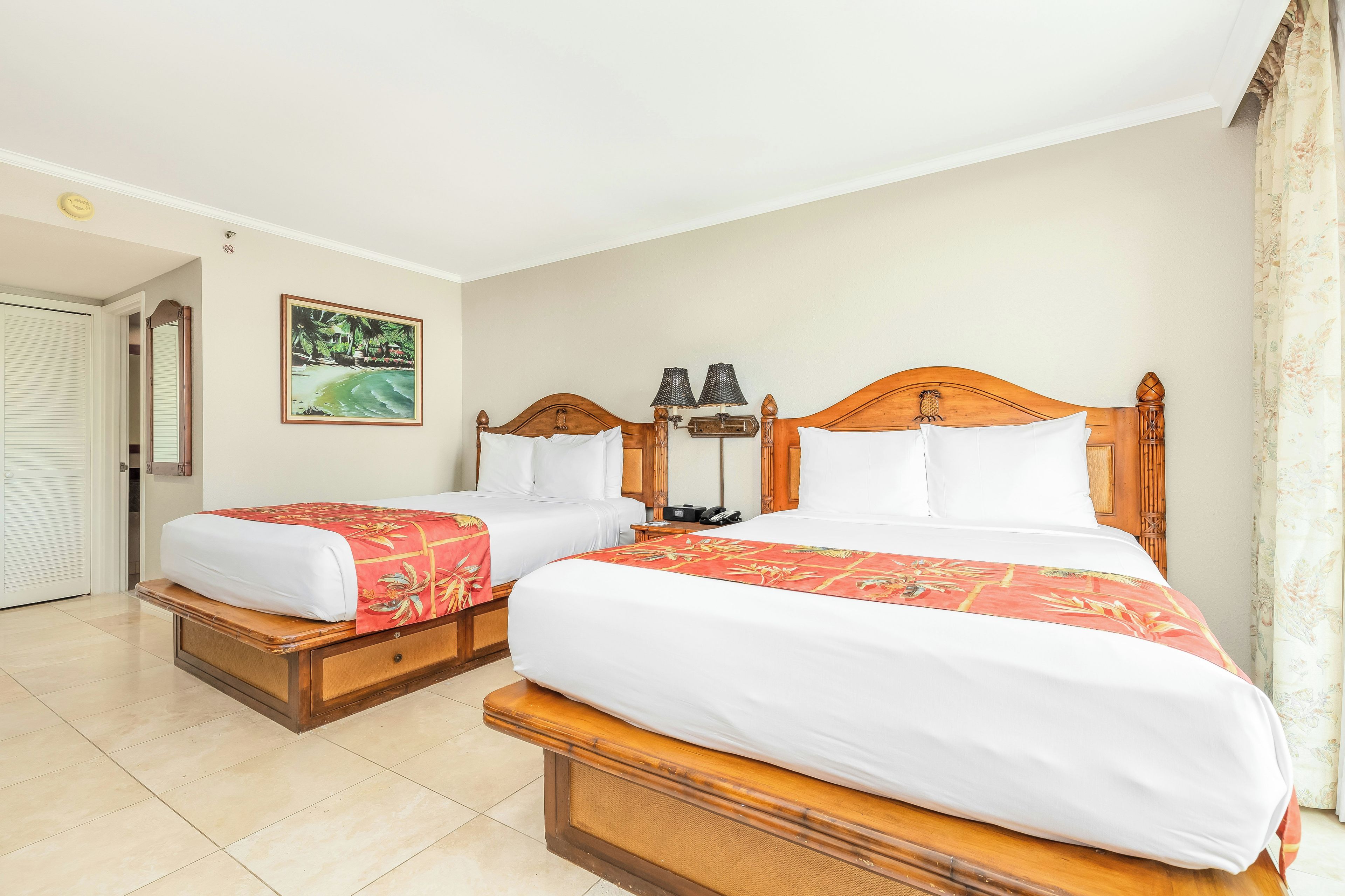 A hotel room with two beds, a painting on the wall, and a door leading to a closet.
