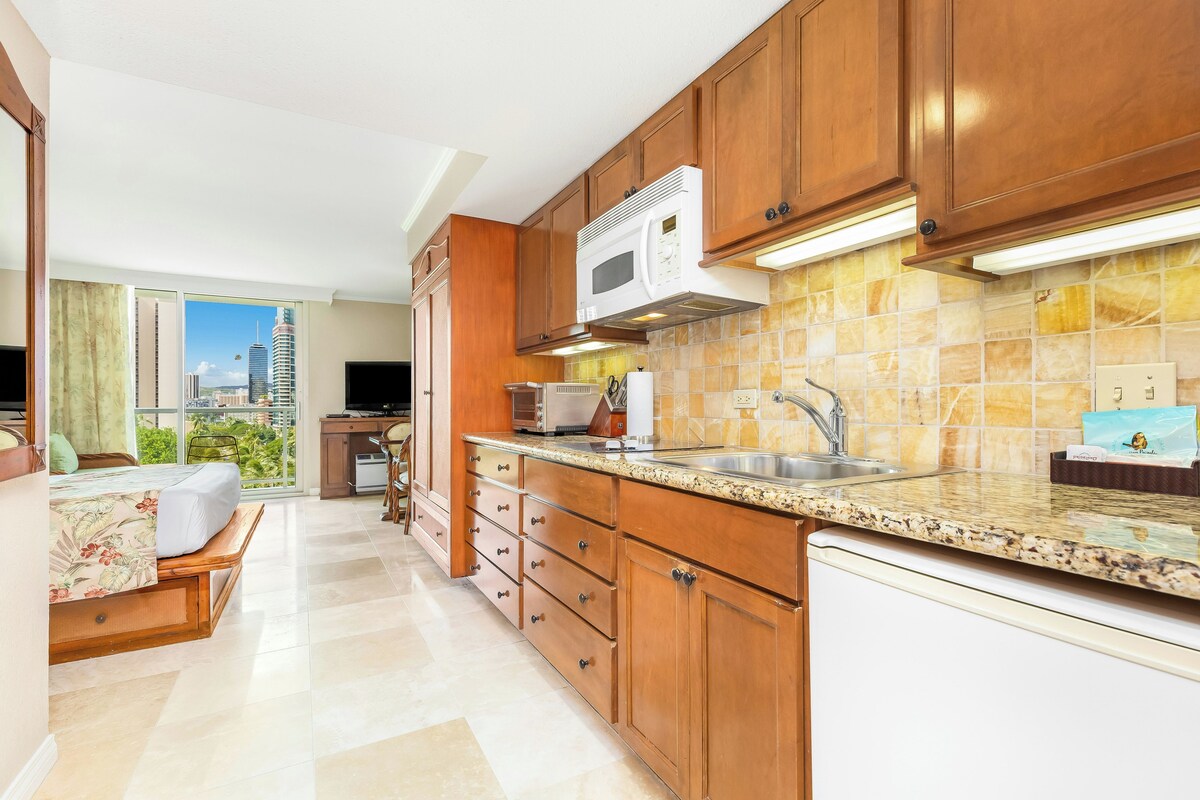 A modern kitchen with wooden cabinets, a microwave, and a sink.