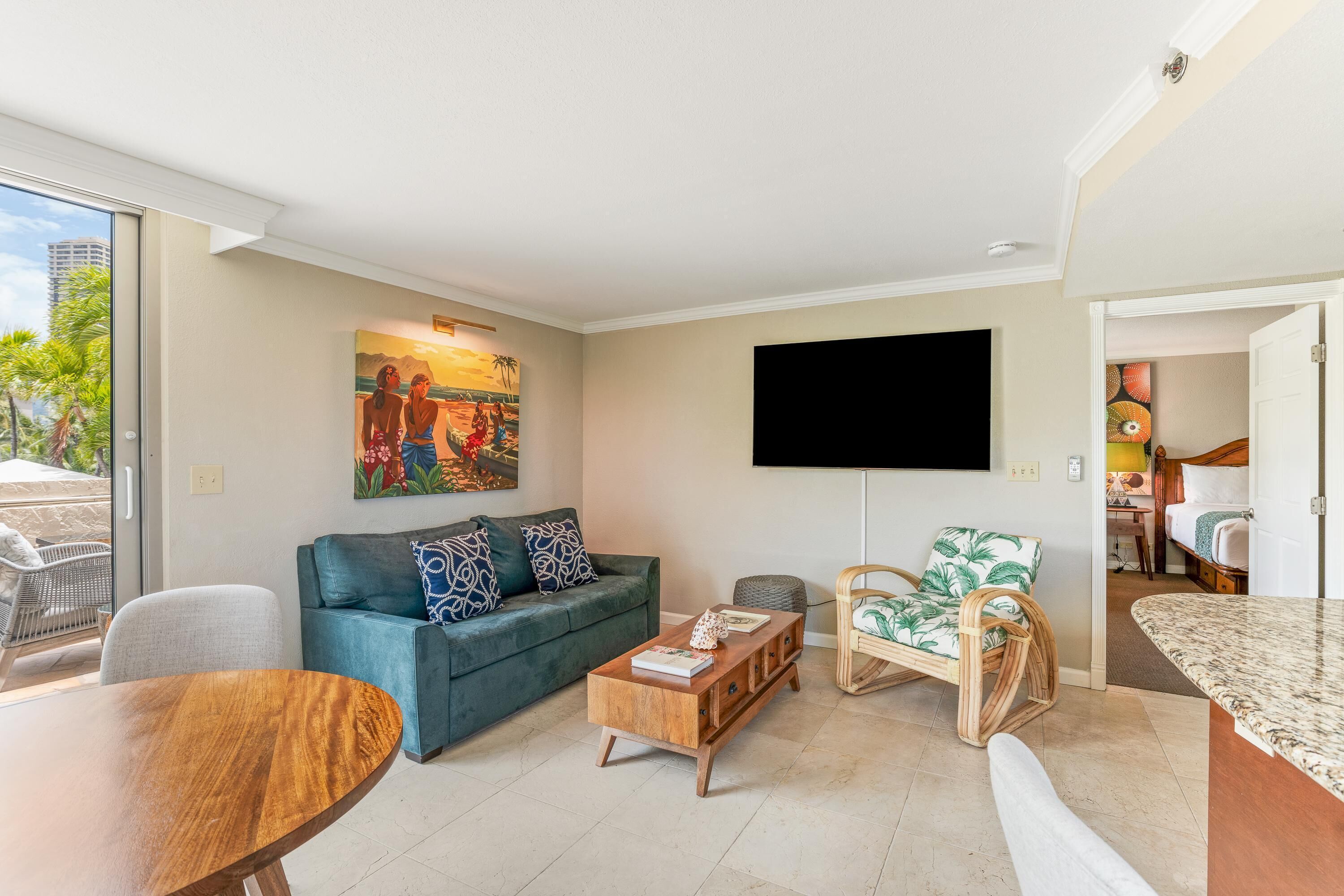 A living room with a sofa, coffee table, TV, and a dining area.