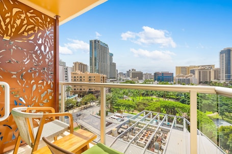 A balcony with a city view, a chair, and a table.