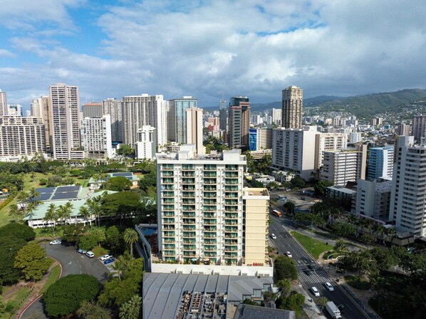 A high-rise hotel with multiple floors, surrounded by a cityscape with various buildings.